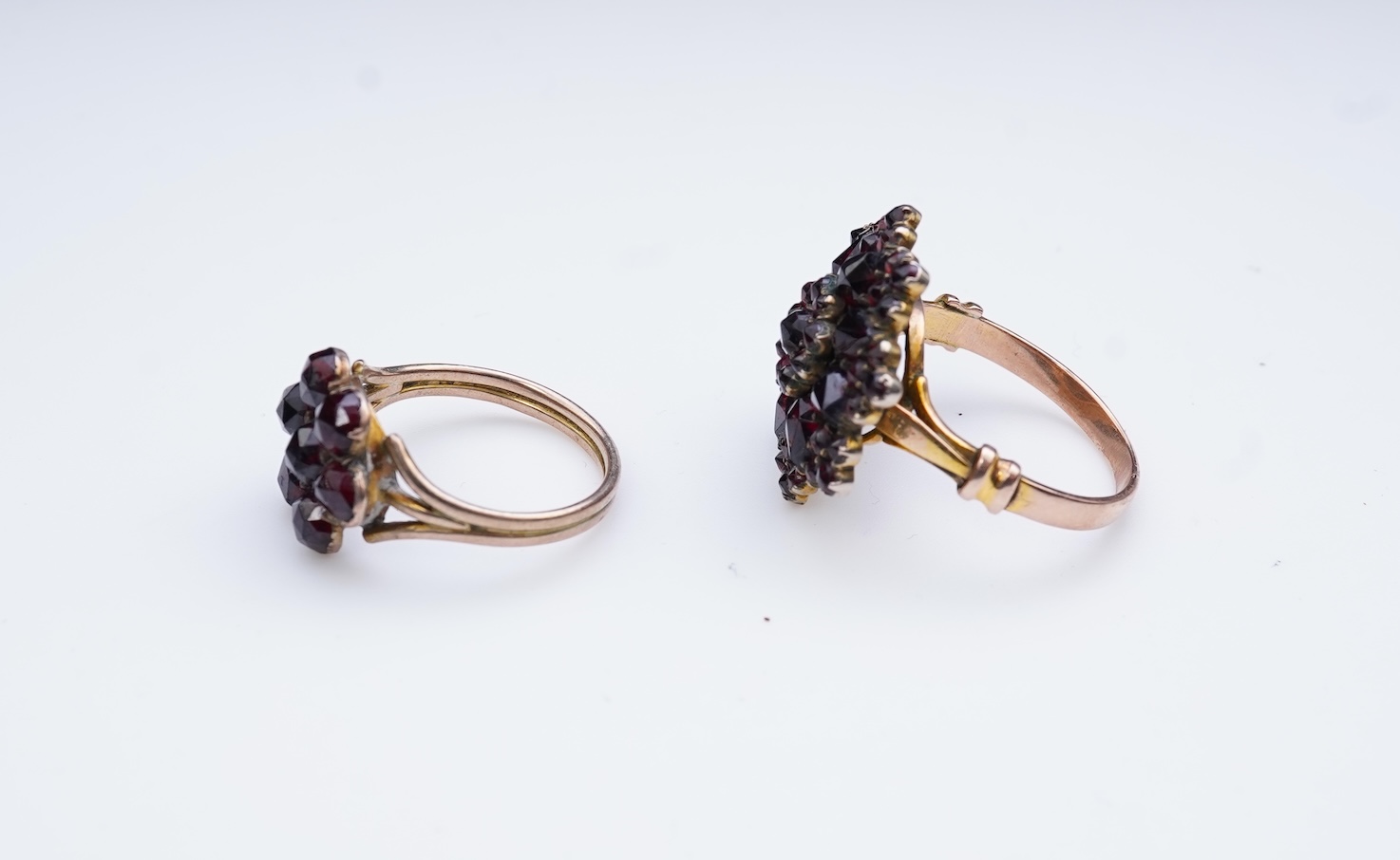 A suite of garnet and paste jewellery, comprising: a brooch, 5cm diameter; a bangle, inner circumference 16cm; two rings, sizes I and M; a pair of earrings, and a single earring, each set with rose-cut garnets; and a pai
